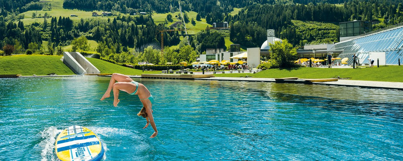 Frau taucht ins Außenbecken der Alpentherme Bad Hofgastein ein