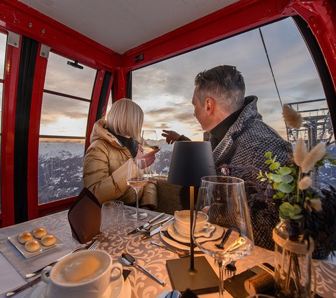 Paar genießt Dinner und Ausblick in der Gondel