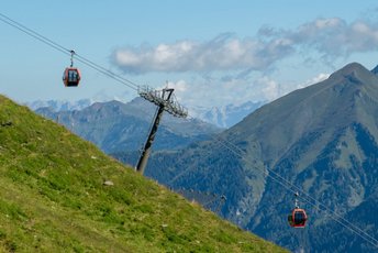 Panoramaaufnahme einer Gondelbahn mit den Gasteiner Bergen im Hintegrund