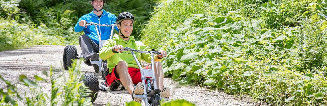 Mountaincartfahrer fahren durch den Wald