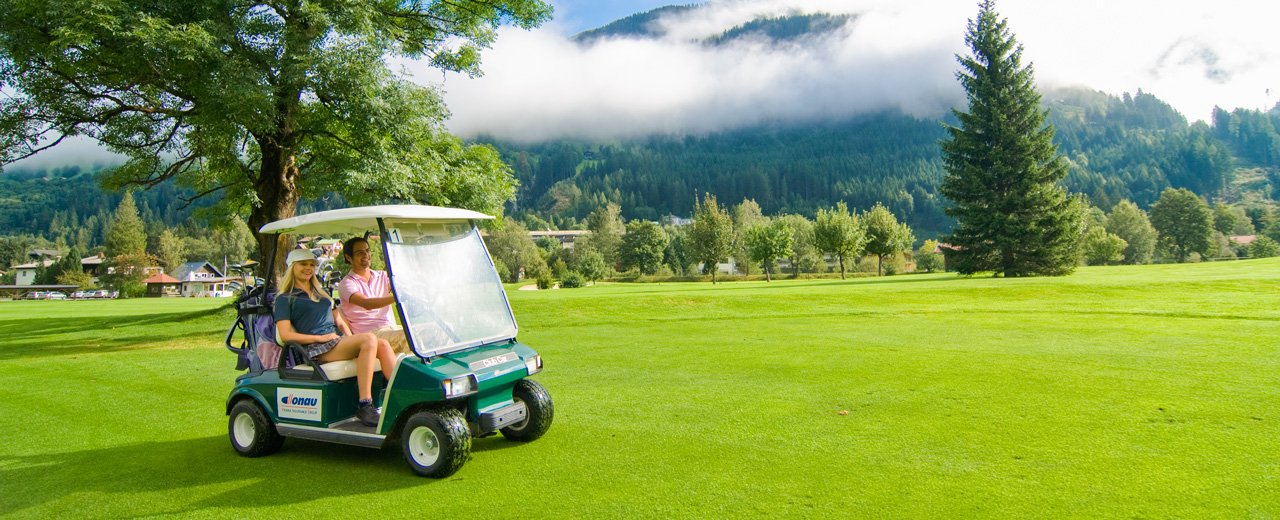 Golfer am Weg mit dem Golf Cart