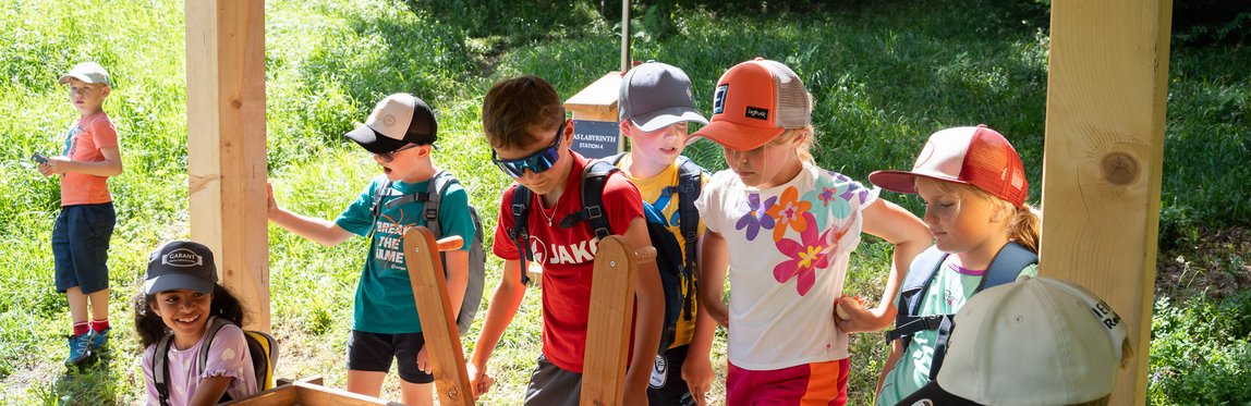 Kinder spielen bei einer Station des Kugelparcours