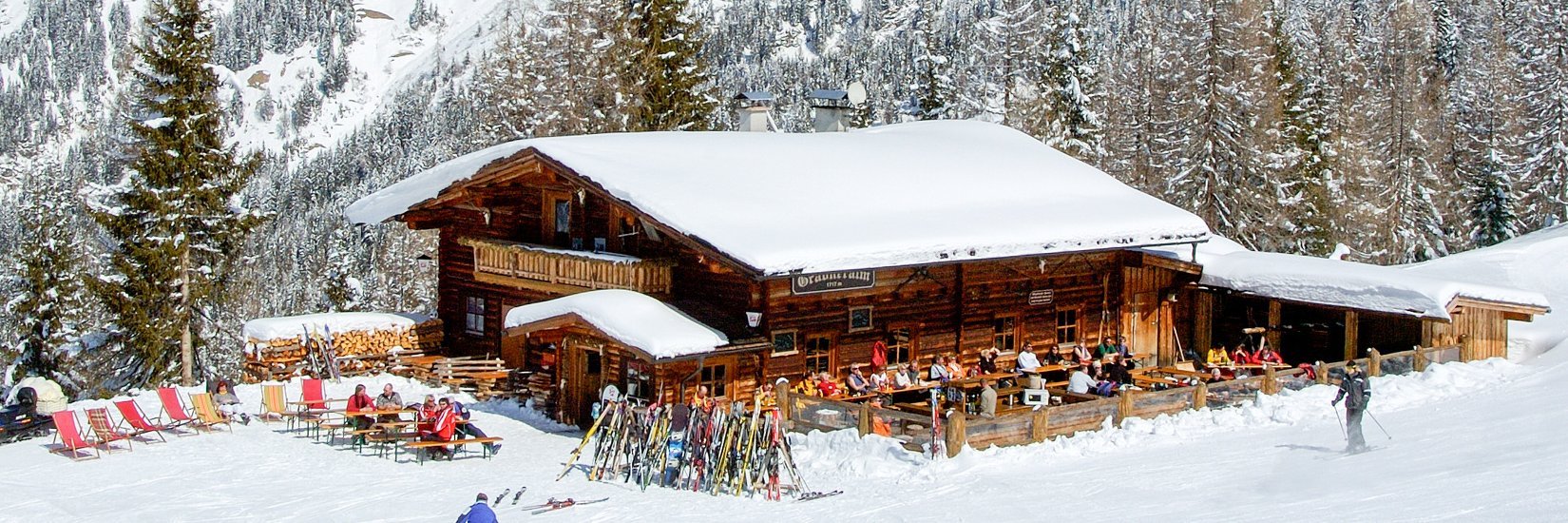 Schneebedeckte Skihütte mit Bergpanorama im Hintergrund