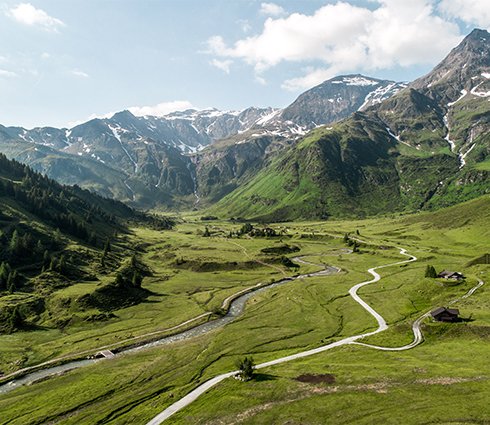 Alpine Landschaft in Sportgastein mit Bachlauf und Bergen der Hohen Tauern