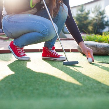 Frau beim Minigolf spielen in Gastein